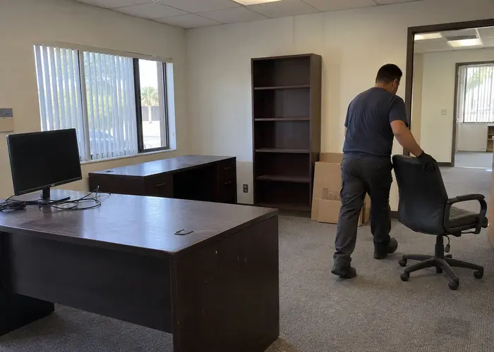 Person moving an office chair beside desks
