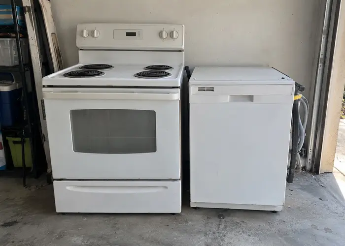Stove and dishwasher beside a garage doorway